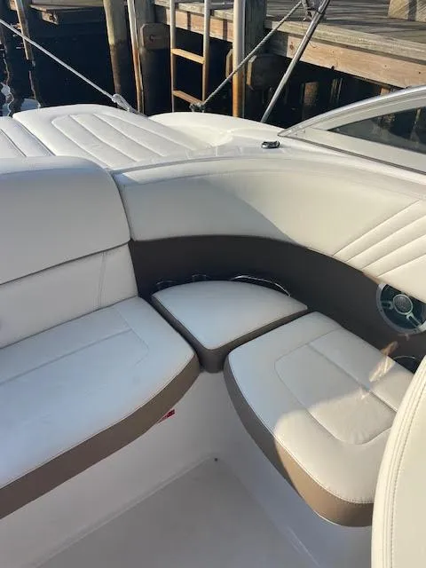 Slide: The Image of 2011 Cobalt 222 boat interior with white and brown seating near dock. - 11