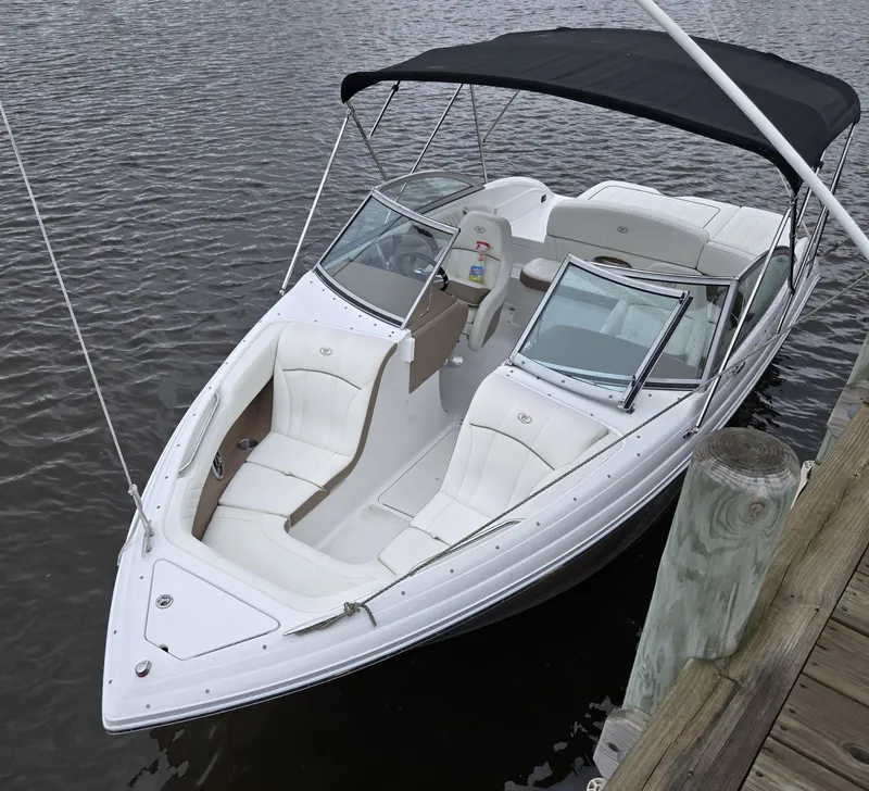 Slide: The Image of 2011 Cobalt 222 boat docked, featuring white seating and a black canopy. - 17