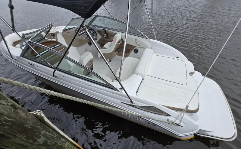 Slide: The Image of 2011 Cobalt 222 boat with white interior, docked on calm water. - 2