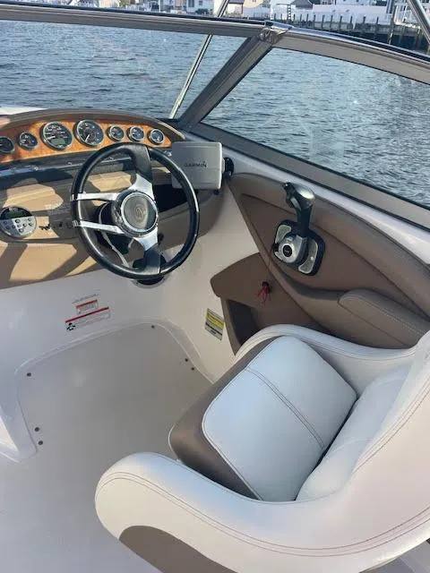 Slide: The Image of 2011 Cobalt 222 boat interior with steering wheel and dashboard, docked by the water. - 20