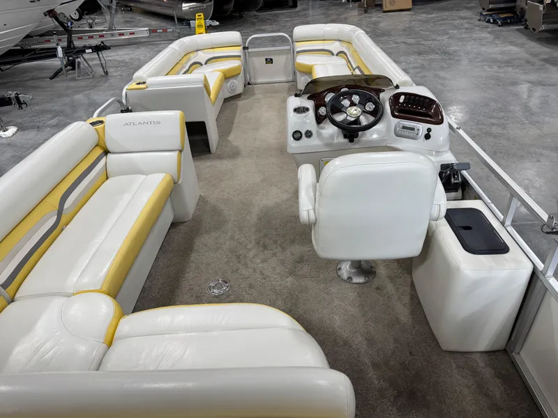 Slide: The Image of 2010 Landau 250 ATLANTIS boat interior with white and yellow seating, steering console, and carpeted floor. - 11