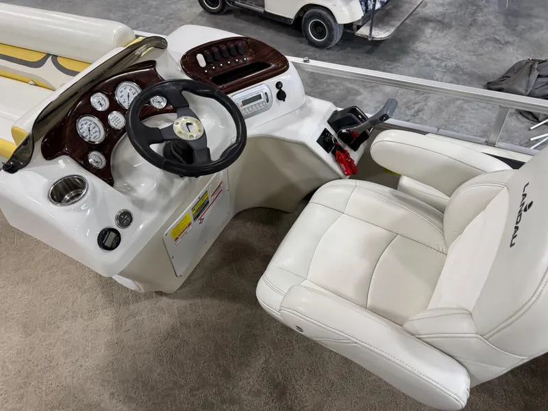 Slide: The Image of 2010 Landau 250 ATLANTIS boat cockpit with steering wheel and white captain's chair. - 12