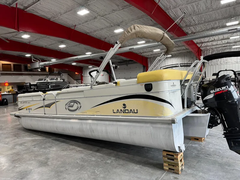 Slide: The Image of 2010 Landau 250 Atlantis pontoon boat in indoor storage with Suzuki outboard motor. - 4