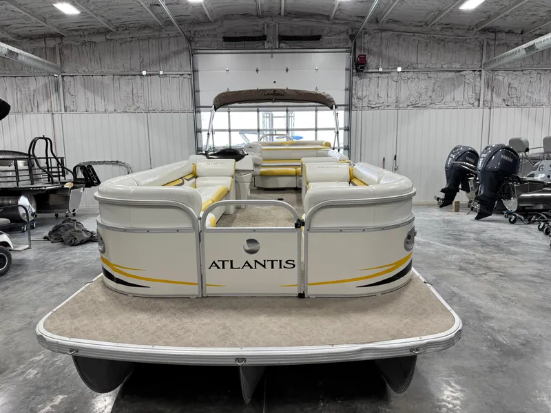 Slide: The Image of 2010 Landau 250 ATLANTIS pontoon boat in a spacious indoor storage facility. - 5