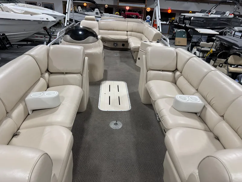 Slide: The Image of 2009 G3 25 ELITE boat with spacious beige seating and cup holders in a showroom. - 7