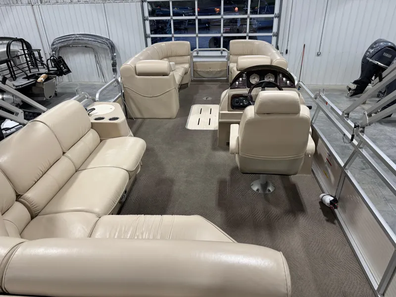 Slide: The Image of 2009 G3 25 ELITE pontoon boat interior with beige seating and steering console. - 8