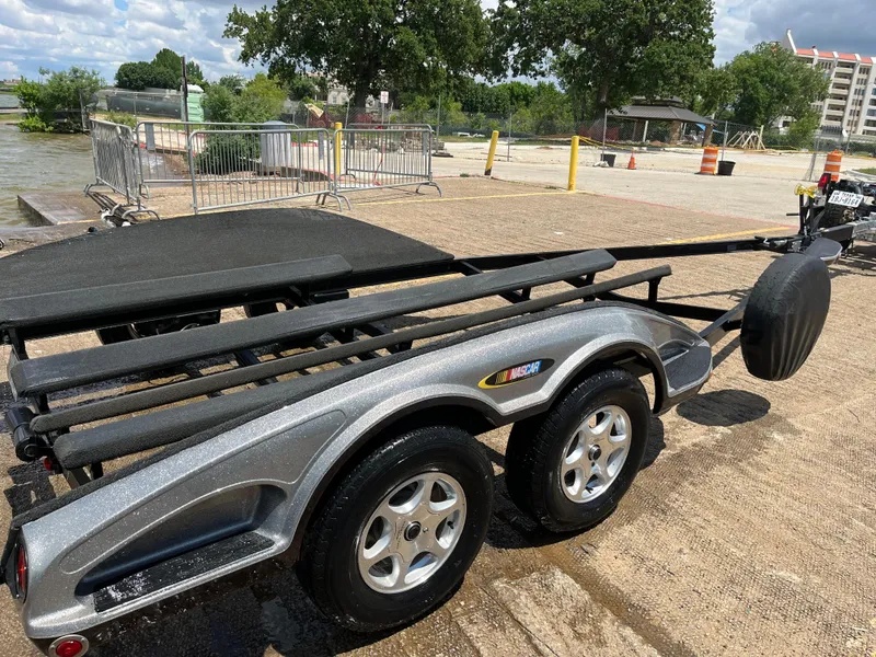 Slide: The Image of 2007 Ranger COMANCHE SERIES Z22 NASCAR boat trailer on a sunny day near water. - 27