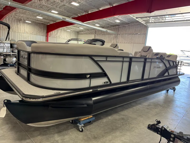 Slide: The Image of 2025 Sylvan L 5 pontoon boat in a showroom, featuring sleek design and comfortable seating. - 24