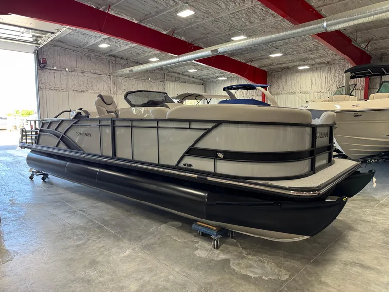Slide: The Image of 2025 Sylvan L 5 pontoon boat in a showroom with red ceiling beams. - 26