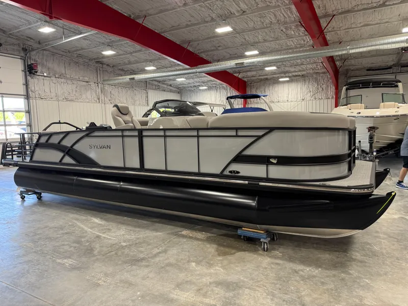 Slide: The Image of 2025 Sylvan L 5 pontoon boat in a showroom with red beams. - 3