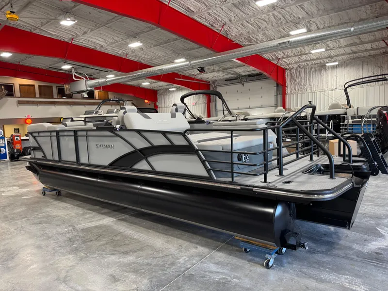 Slide: The Image of 2025 Sylvan L 5 pontoon boat in a showroom with red ceiling beams. - 7