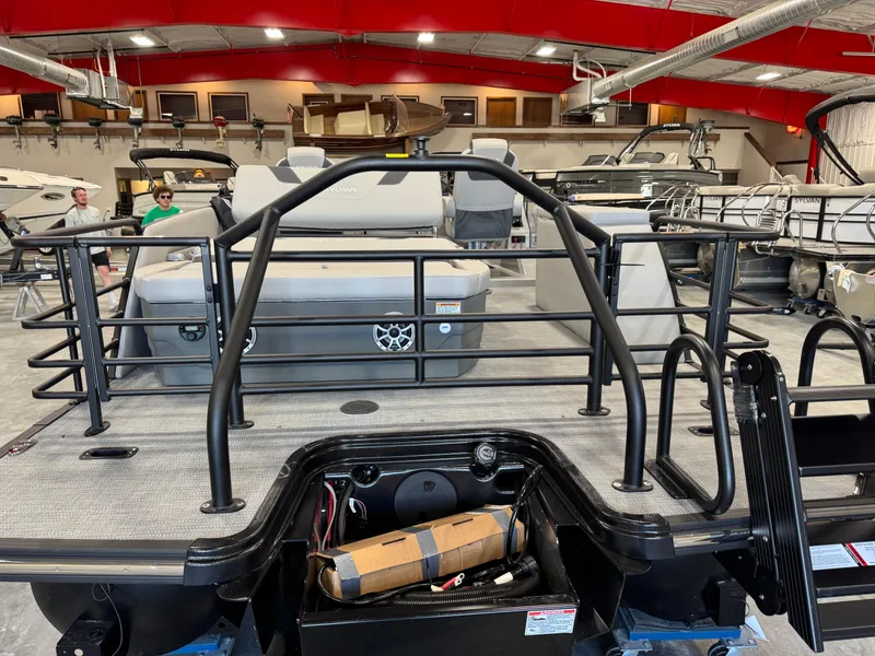Slide: The Image of 2025 Sylvan L 5 pontoon boat interior in showroom with red ceiling and various boats. - 8