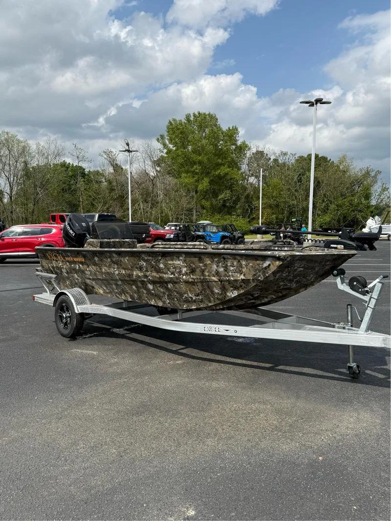 Slide: The Image of 2025 Excel 1751 Side Console River Warrior boat on trailer in parking lot. - 12