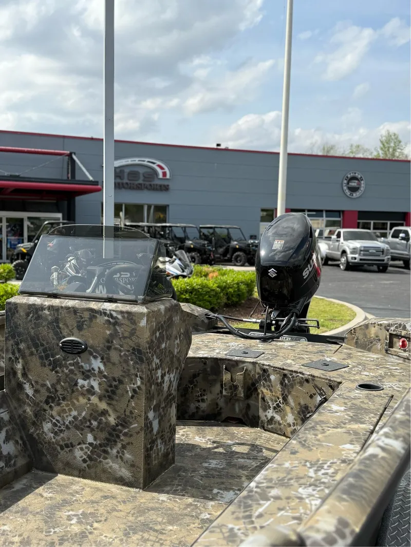Slide: The Image of 2025 Excel 1751 Side Console River Warrior boat with camouflage design and Suzuki outboard motor. - 13
