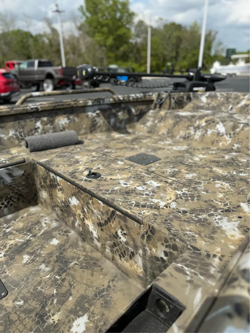 Slide: The Image of 2025 Excel 1751 Side Console River Warrior with camouflage design in a parking lot. - 16