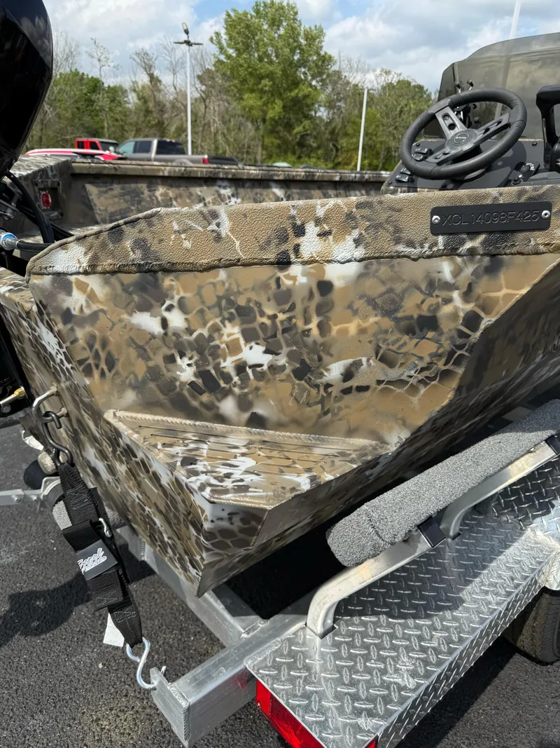 Slide: The Image of 2025 Excel 1751 Side Console River Warrior boat with camouflage design on a trailer. - 3