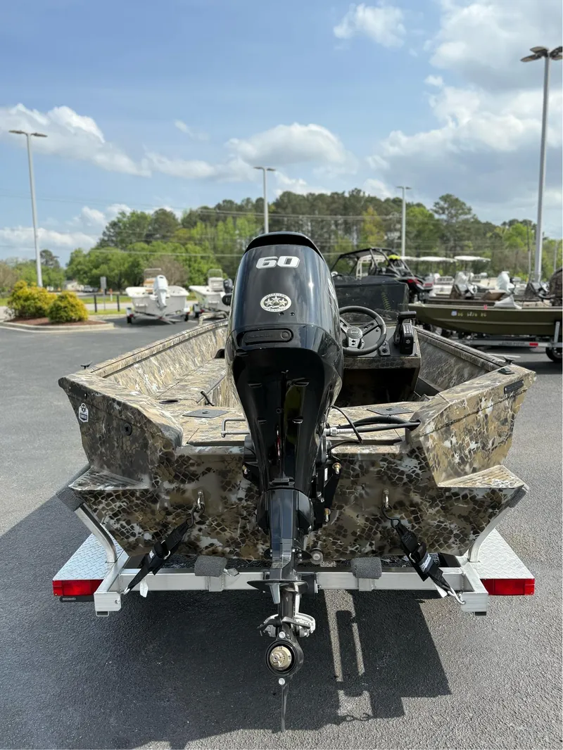 Slide: The Image of 2025 Excel 1751 Side Console River Warrior boat with 60 HP motor, parked outdoors. - 7