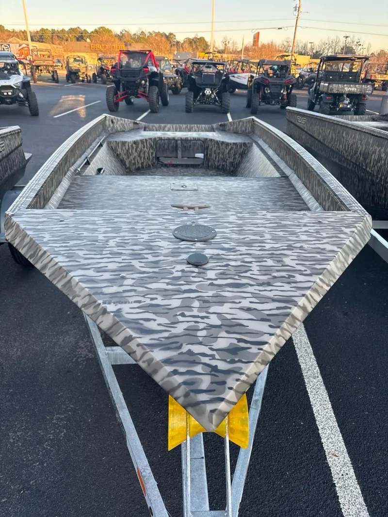 Slide: The Image of 2025 EDGE BOATS 656 SPORTSMAN with camouflage design on a trailer in a parking lot. - 3