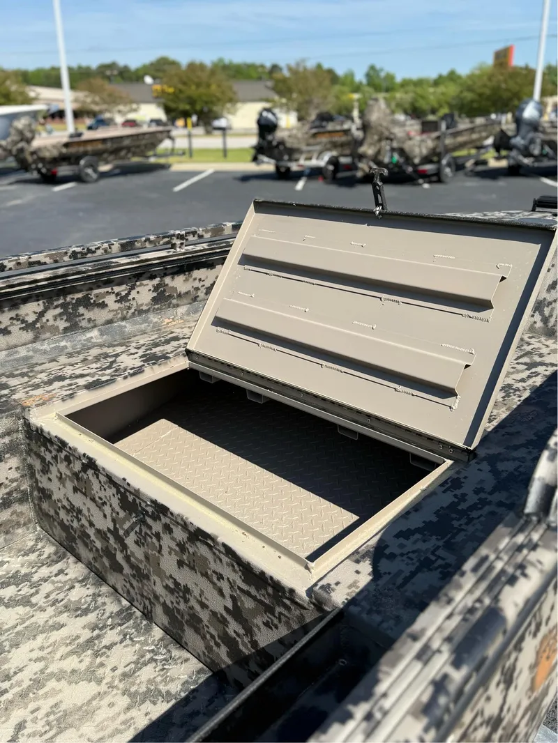 Slide: The Image of Open storage compartment on 2025 EDGE BOATS 653 DB with camouflage design. - 11