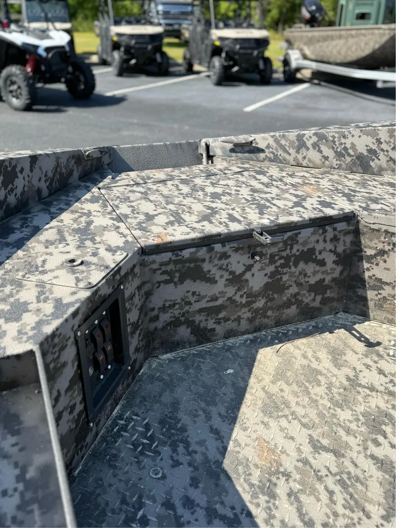 Slide: The Image of 2025 EDGE BOATS 653 DB with camouflage interior, parked near off-road vehicles. - 12