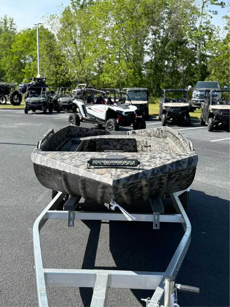 Slide: The Image of 2025 EDGE BOATS 653 DB on trailer, parked outdoors with off-road vehicles in background. - 6