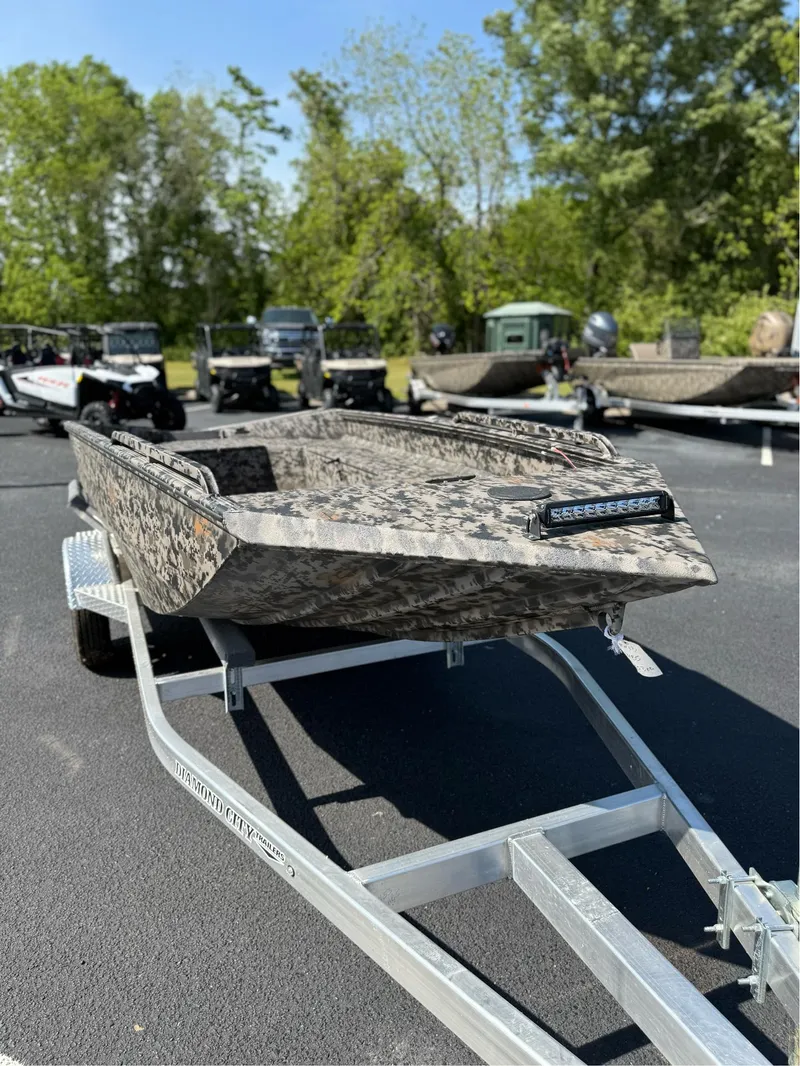 Slide: The Image of 2025 EDGE BOATS 653 DB on trailer, camo design, parked outdoors. - 8
