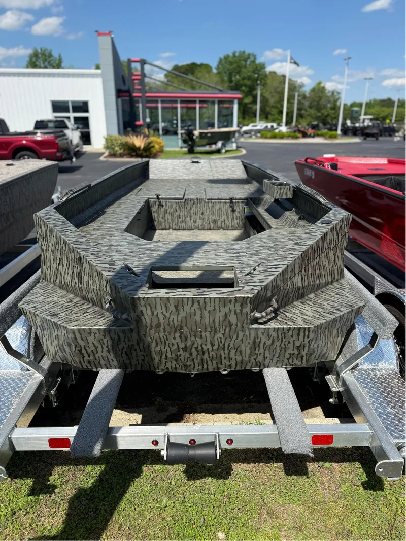 Slide: The Image of 2025 EDGE BOATS 556DB on trailer, camo design, parked outdoors at dealership. - 3