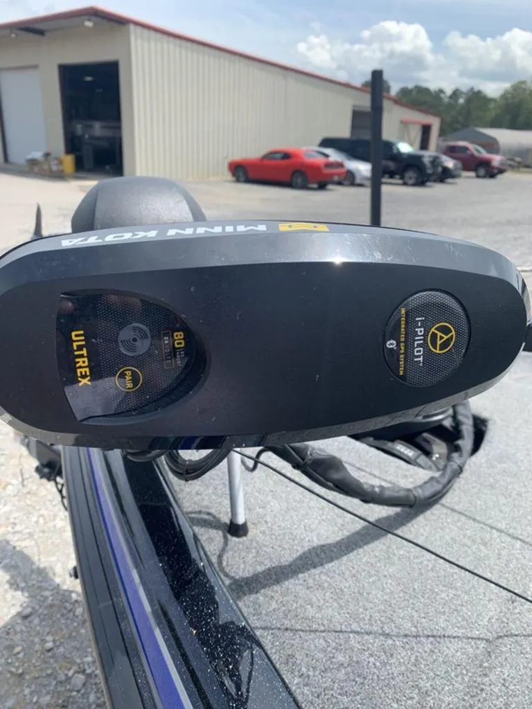 Slide: The Image of 2024 Phoenix Bass Boats 518 Pro with Minn Kota Ultrex motor in a parking lot. - 2