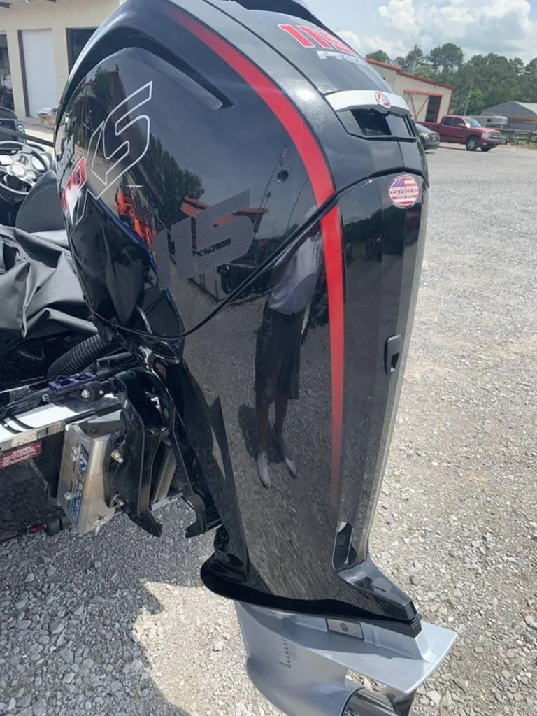 Slide: The Image of 2024 Phoenix Bass Boats 518 Pro with powerful outboard motor, parked on gravel. - 6