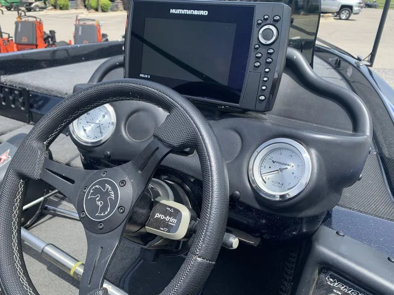 Slide: The Image of 2024 Phoenix Bass Boats 518 Pro dashboard with steering wheel and Humminbird Helix 8 display. - 7