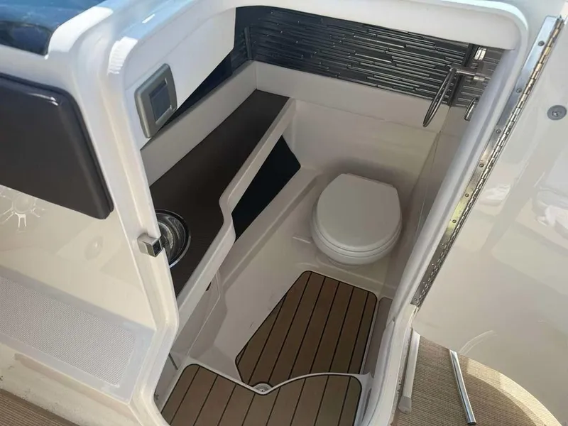 Slide: The Image of 2023 Sea Ray SLX 310 boat interior with compact bathroom and modern fixtures. - 10