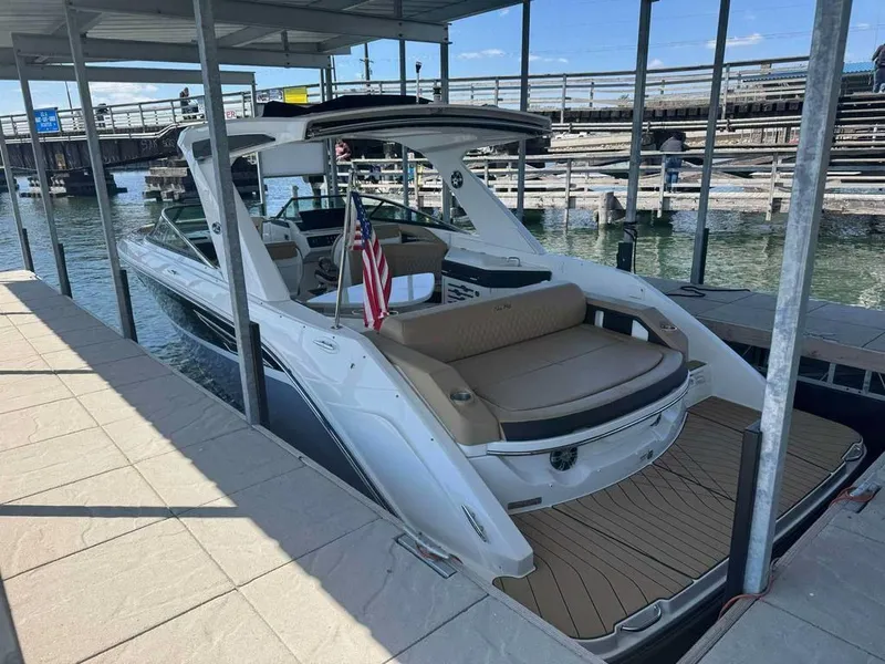 Slide: The Image of 2023 Sea Ray SLX 310 boat docked, featuring sleek design and American flag. - 2