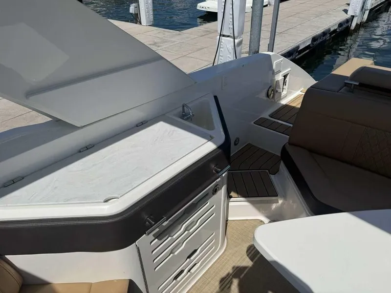 Slide: The Image of 2023 Sea Ray SLX 310 boat interior with seating and storage at a dock. - 6
