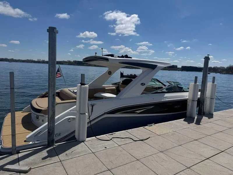 Slide: The Image of 2023 Sea Ray SLX 310 boat docked on a sunny day with clear skies. - 9