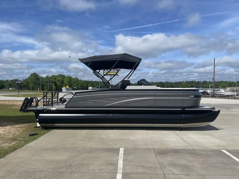 Slide: The Image of 2025 Sylvan G-3 DLZ DH pontoon boat parked on concrete under a blue sky. - 1