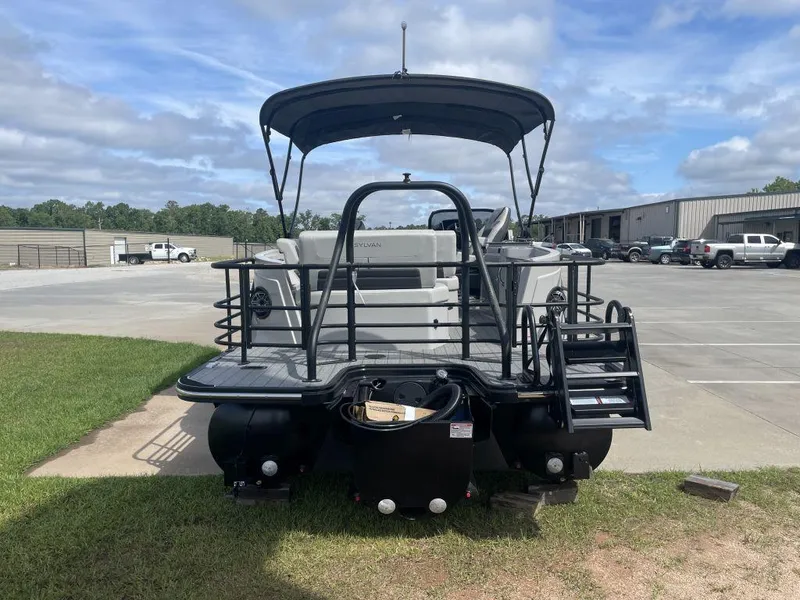 Slide: The Image of 2025 Sylvan G-3 DLZ DH boat, rear view in a parking lot under a cloudy sky. - 4