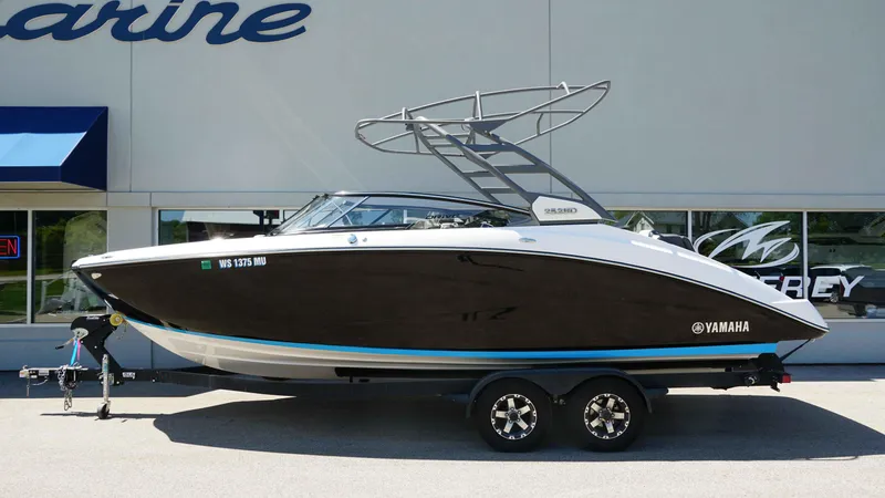 Slide: The Image of 2021 Yamaha Boats 252SD on trailer, parked outside a marine dealership. - 2