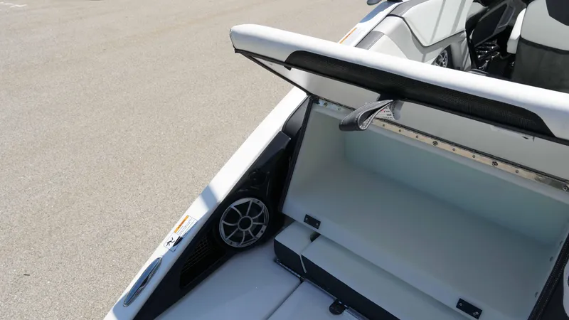 Slide: The Image of 2021 Yamaha Boats 252SD storage compartment with speaker, open on deck. - 20
