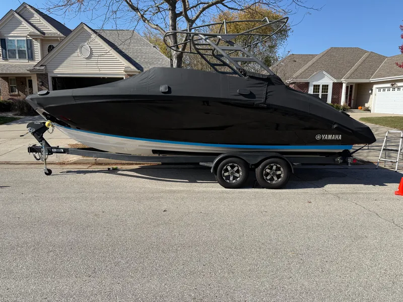 Slide: The Image of 2021 Yamaha Boats 252SD covered on trailer, parked in residential area. - 23