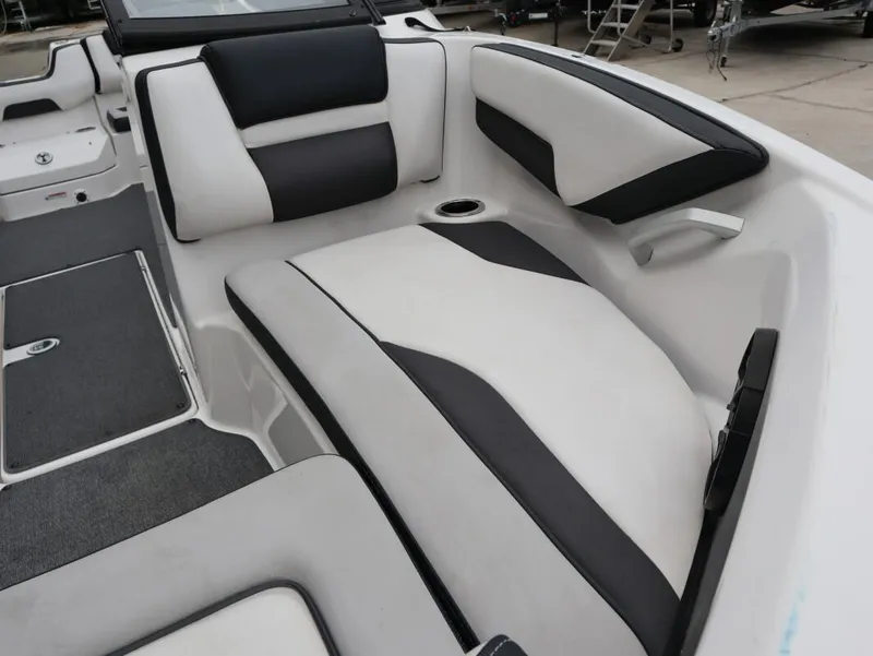 Slide: The Image of 2019 Yamaha Boats SX195 interior with black and white seating, cup holder, and storage compartments. - 13