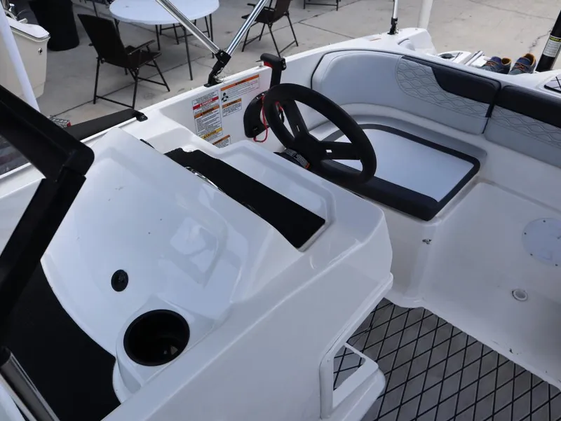Slide: The Image of 2023 Bayliner Element M17 boat interior with steering wheel and seating area. - 23