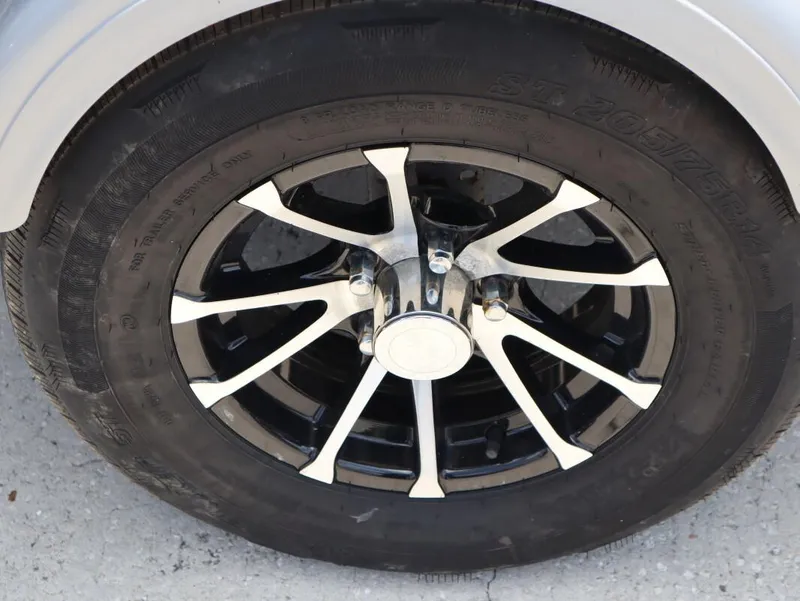 Slide: The Image of 2023 Bayliner Element M17 trailer wheel with black and silver alloy rim. - 24