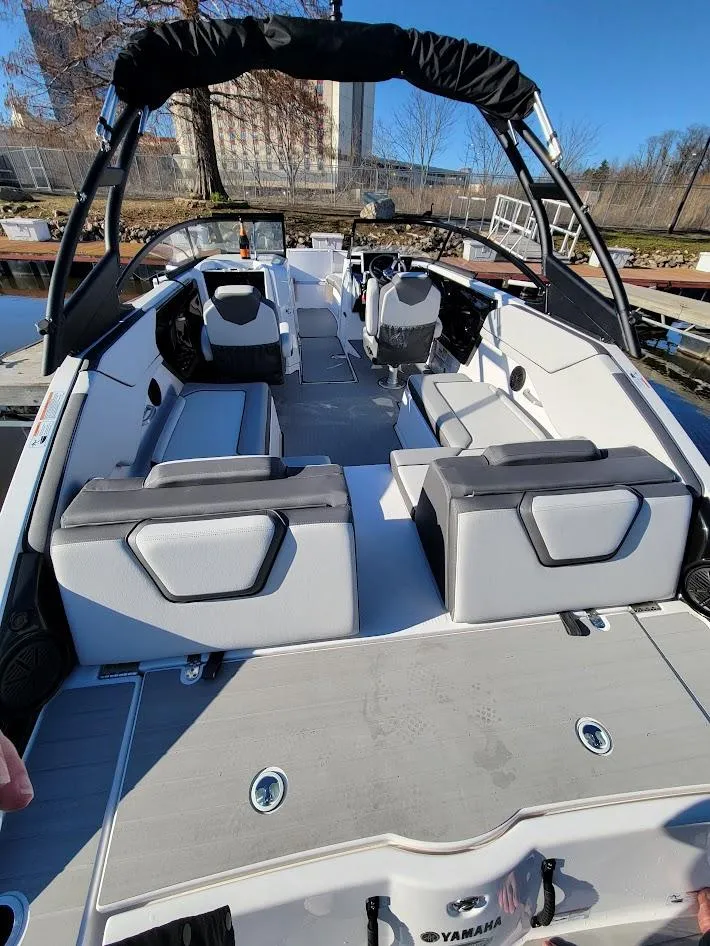 Slide: The Image of 2023 Yamaha Boats AR250 with sleek interior and modern design, docked under clear blue sky. - 12