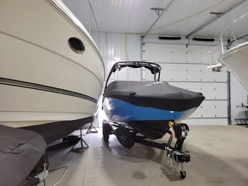 Slide: The Image of 2023 Yamaha Boats AR250 in storage, covered and on trailer, inside a spacious garage. - 17