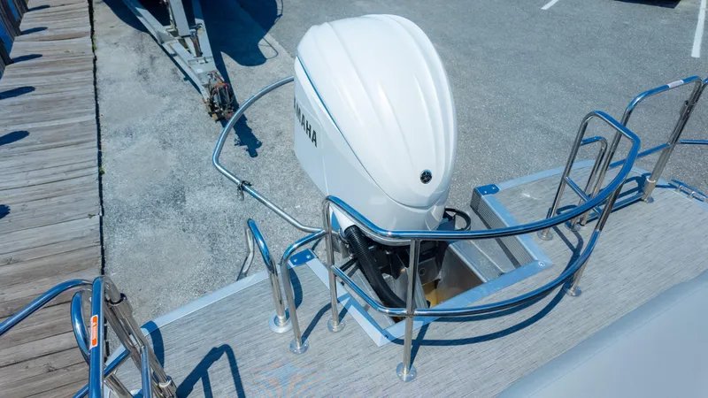 Slide: The Image of 2022 Bennington 24 LXSBA boat with Yamaha outboard motor, docked on a sunny day. - 16