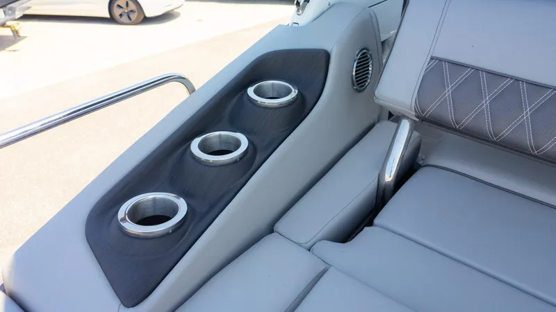 Slide: The Image of 2022 Bennington 24 LXSBA boat interior with cup holders and cushioned seating. - 17