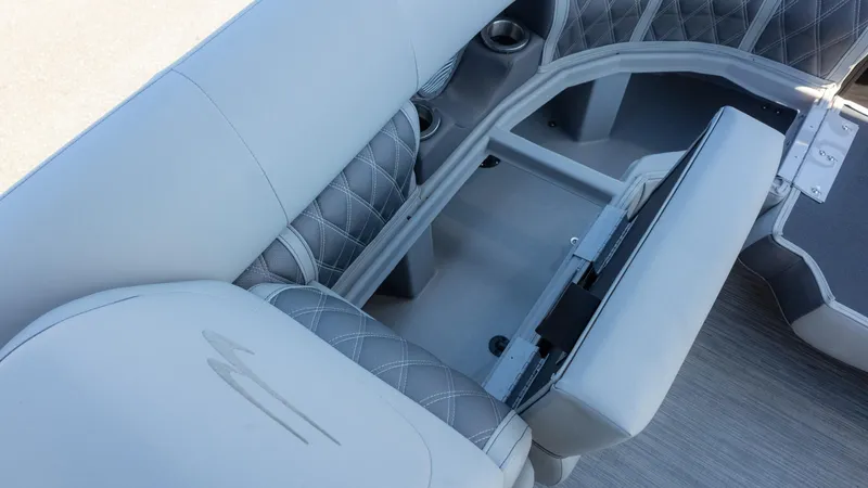 Slide: The Image of Bennington 24 LXSBA 2022 boat interior with open storage compartment and cushioned seating. - 23