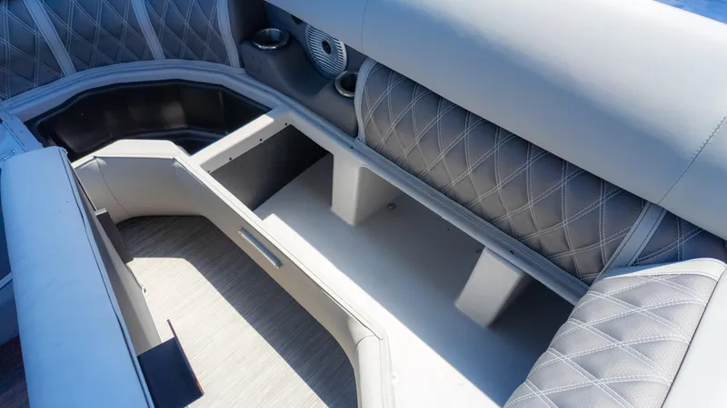 Slide: The Image of 2022 Bennington 24 LXSBA boat interior with open storage compartment and quilted seating. - 25