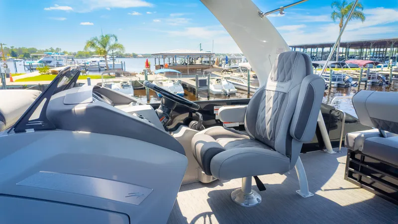 Slide: The Image of Luxurious 2022 Bennington 24 LXSBA boat interior with plush seating at a marina. - 28