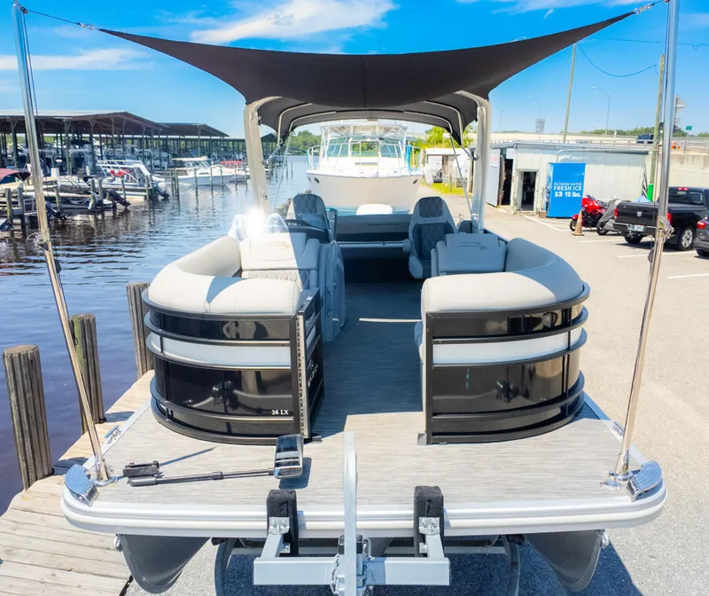 Slide: The Image of 2022 Bennington 24 LXSBA pontoon boat docked at marina under sunny skies. - 3